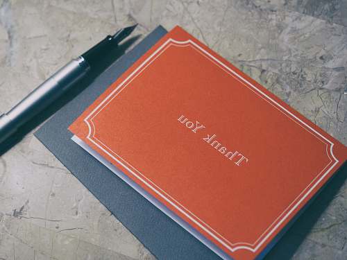 card fountain pen next to red Thank You journal notelet